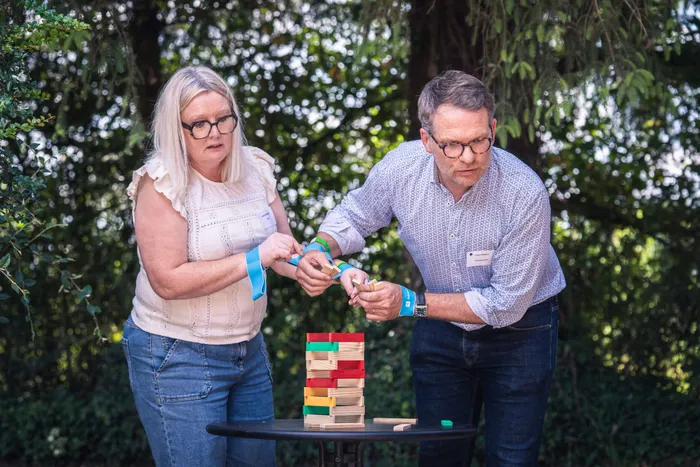 Deux participants concentrés sur un jeu de construction en extérieur