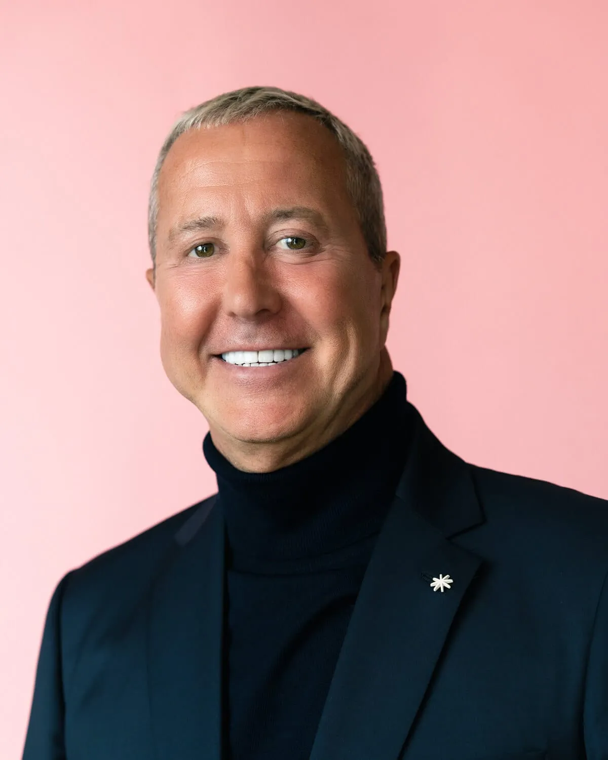 Portrait corporate en veste sombre sur fond rose, par Paul Parmentier