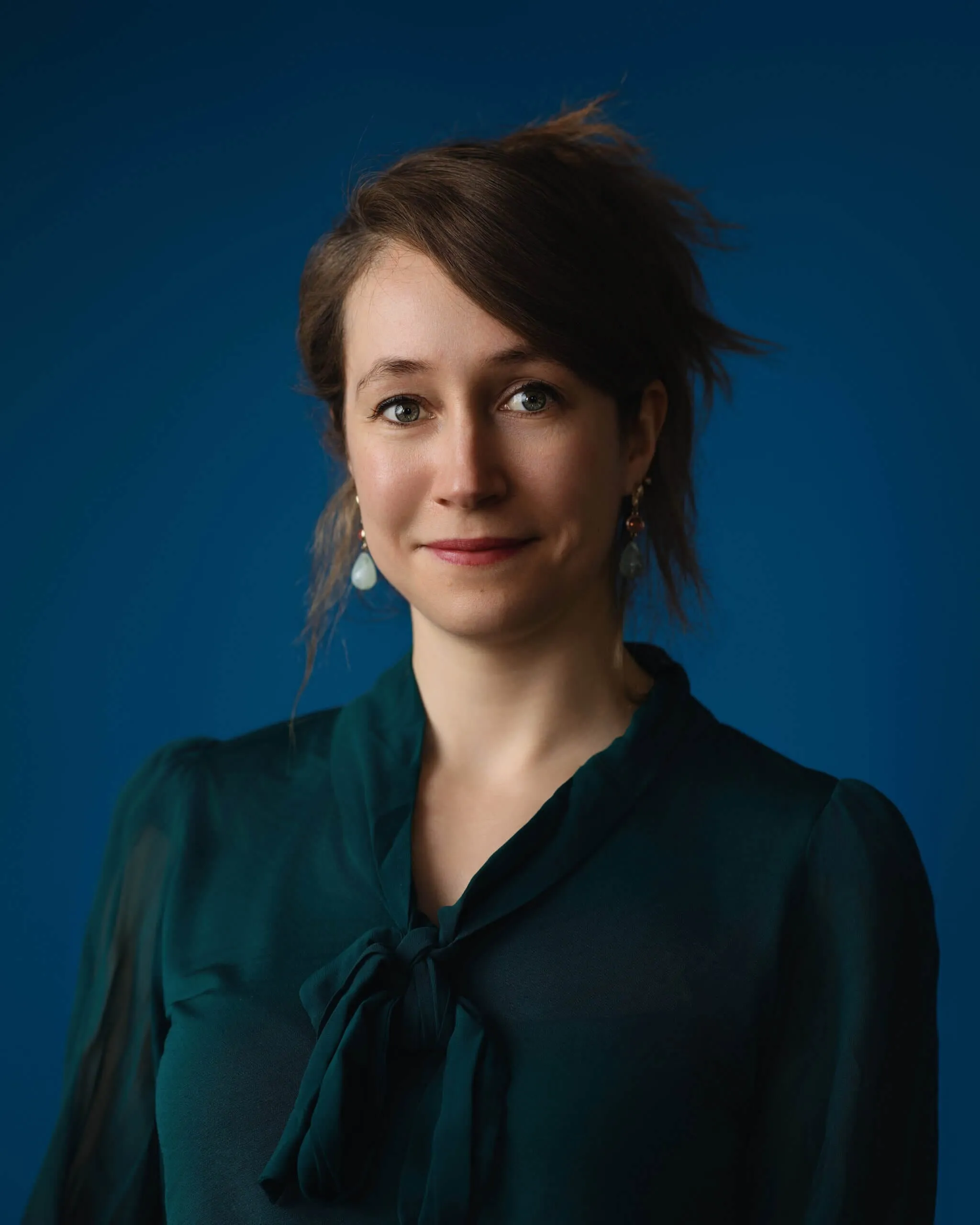 Portrait corporate en tenue sobre sur fond bleu profond